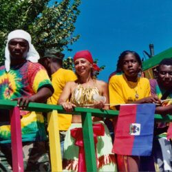 People on colorful parade float with flags