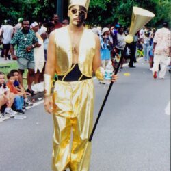 Parade performer in gold crown and staff