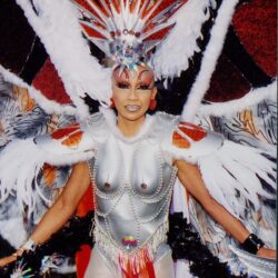 Drag performer in silver and red feathered costume