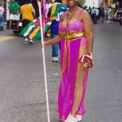 Woman in purple carnival costume holding staff