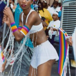 Performer in rainbow costume dancing at parade