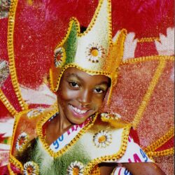 Smiling child in golden carnival feathered costume