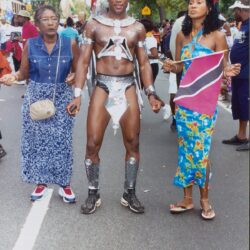 Parade participants holding hands, man in costume