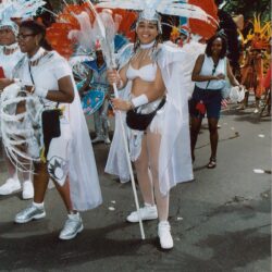 Women in white feathered carnival costumes marching