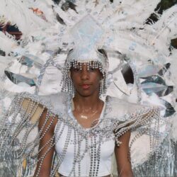 Person wearing ornate white feathered carnival costume