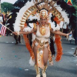 Carnival dancer wearing large feathered gold costume