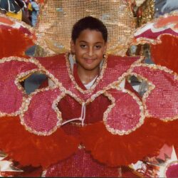 Smiling child in red feathered carnival costume