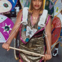 Carnival performer in sequined costume holding stick