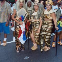 Four people in Egyptian-style gold costumes at parade