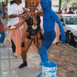 Two festival performers, one covered in blue paint