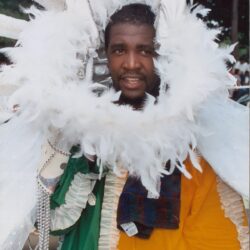 Man in colorful costume with feathered headdress.