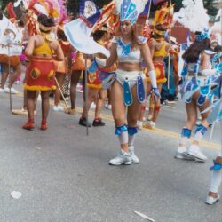 Carnival dancers in colorful costumes on street.