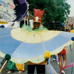 Person in colorful costume at street parade.