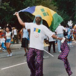 Man waving flag at street festival parade.