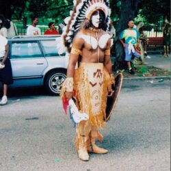 Man in traditional costume with feathered headdress.
