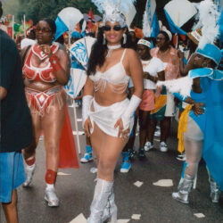 Woman in white feathered carnival costume smiling