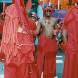 People wearing red carnival costumes at parade