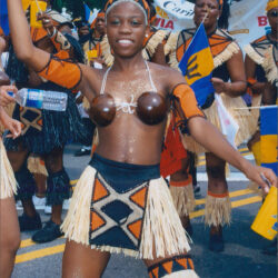 Smiling woman in carnival costume dancing in parade