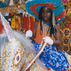 Young girl in colorful hat riding decorated horse