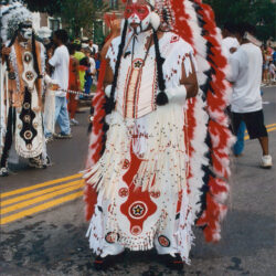 Parade participant in red white feathered headdress