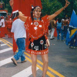 Woman in red carnival costume dancing on street