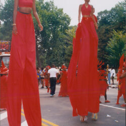 Two stilt walkers in flowing red costumes
