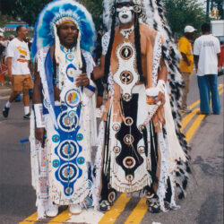 Two people in elaborate feathered parade costumes