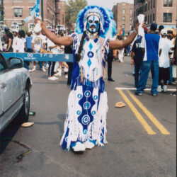 Festival performer with face paint and feathers