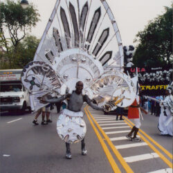 Parade participant in large silver carnival costume