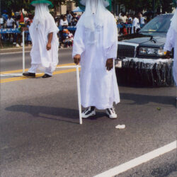 People in white robes and veils marching
