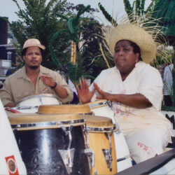 Two drummers playing congas at outdoor festival