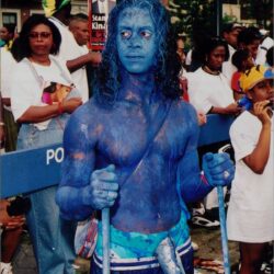 Man painted blue at outdoor event.