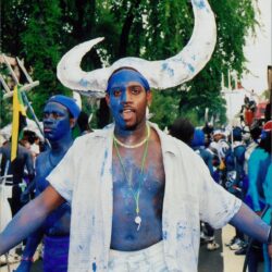 Person in blue paint with horned headdress.