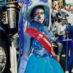 Carnival participant in blue costume and makeup.