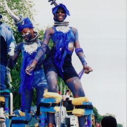 Performers in blue costumes on stilts.