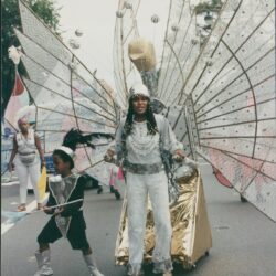 Carnival performers in elaborate winged costumes.