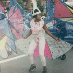 Person in colorful costume at street festival.