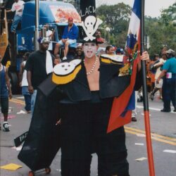 Person in costume holding a Haitian flag.