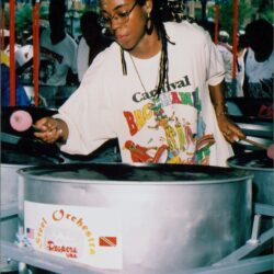 Person playing steelpan at a carnival event.