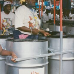 Woman playing steel drums at a carnival.