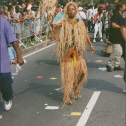 Person in straw costume at street parade.