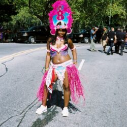 Carnival dancer in colorful costume on street.
