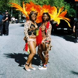 Carnival dancers in vibrant feathered costumes.
