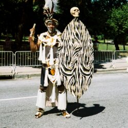 Man in tribal costume with feather headdress.
