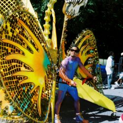 Man in colorful dragon costume at parade.