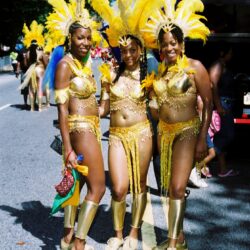 Three women in festive yellow carnival costumes.