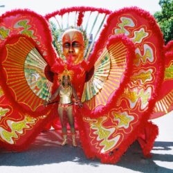 Carnival performer in vibrant red costume.