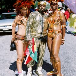 Three people in gold carnival costumes