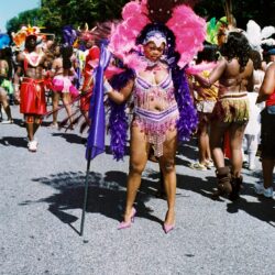 Carnival performer in colorful feathered costume.