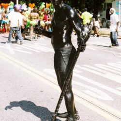 Man painted black in street parade.